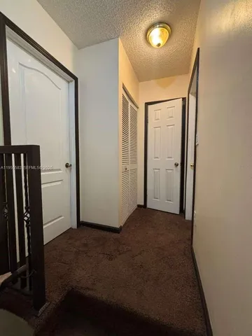 an empty room with closet area and wooden floor