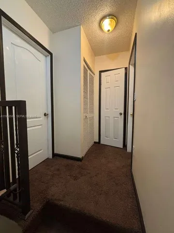an empty room with closet area and wooden floor