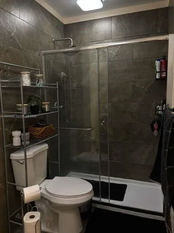 a bathroom with a toilet and a shower