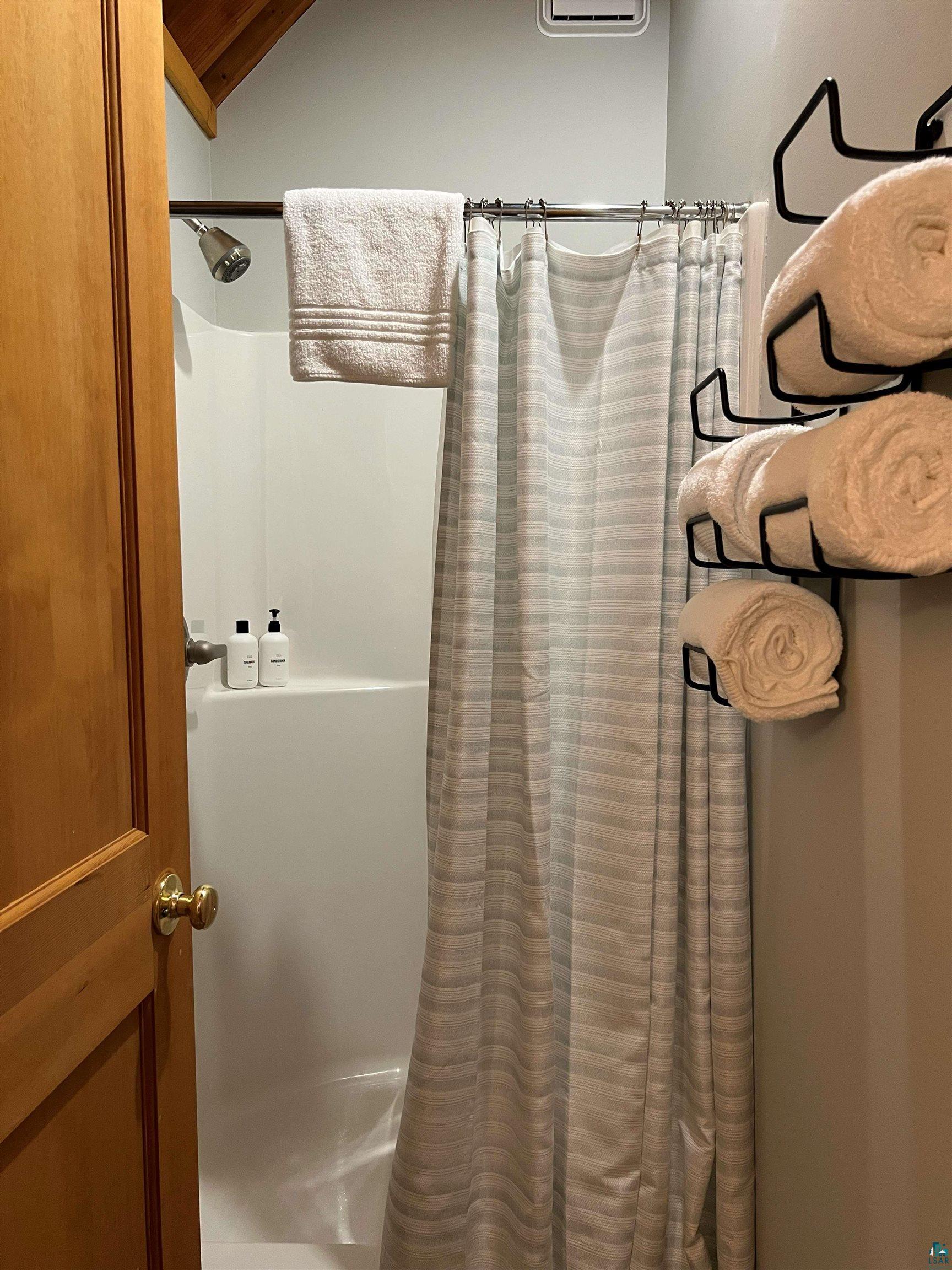 87645 Bjorn Road Bayfield, WI 54814 - Photo 9 of 13 Bathroom featuring curtained shower and vaulted ceiling