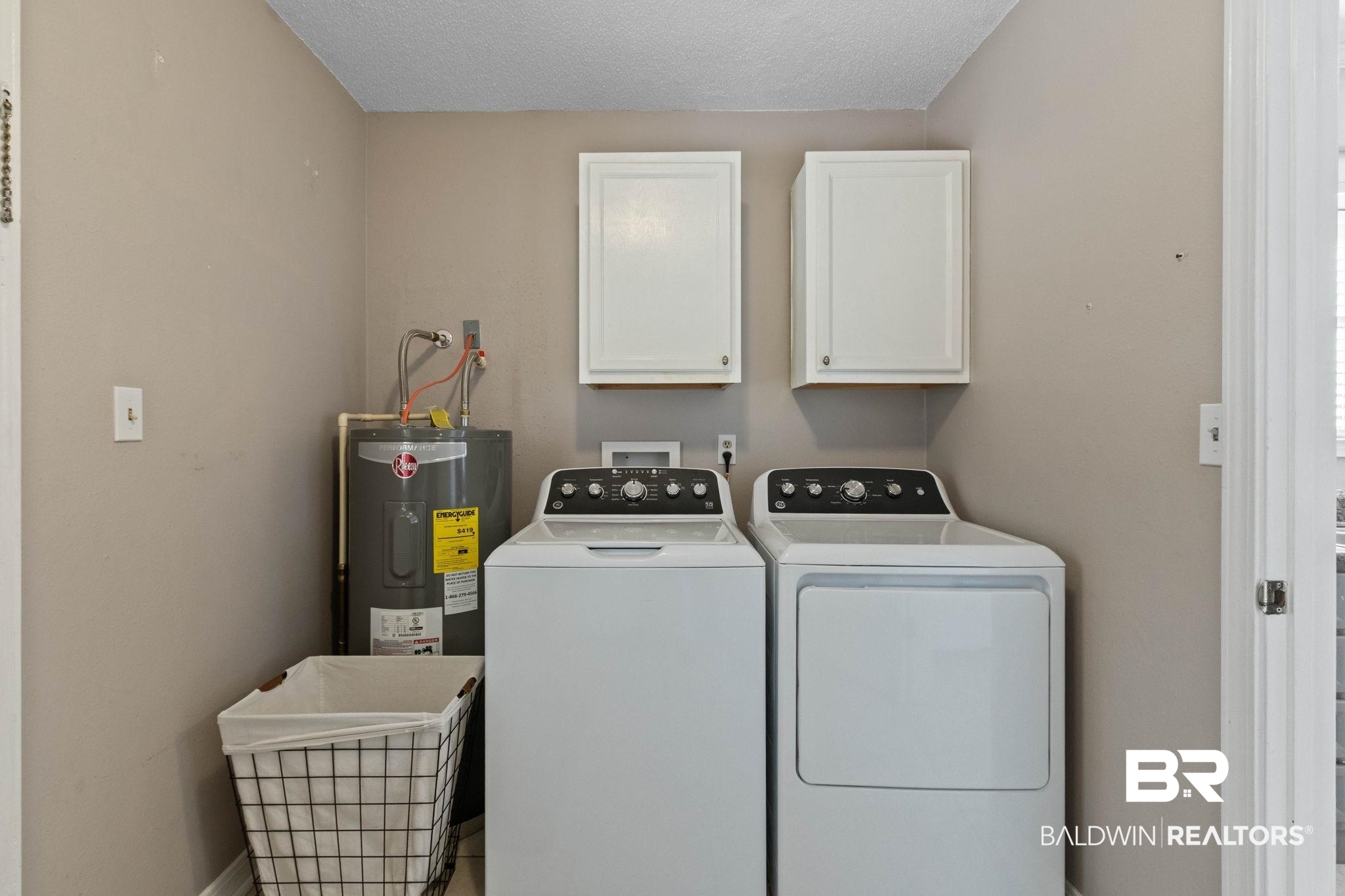 5366 Scanlan Way West Satsuma, AL 36572 - Photo 28 of 43 Laundry room featuring washing machine and dryer, cabinet space, a textured ceiling, and electric water heater