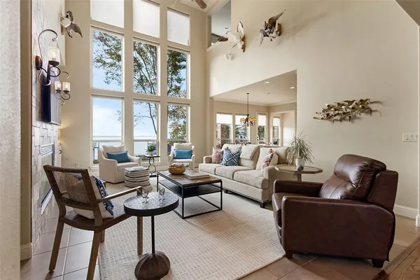 a living room with furniture a chandelier and a large window