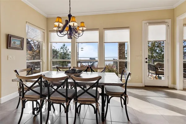a dining room with wooden floor a chandelier a wooden table and chairs