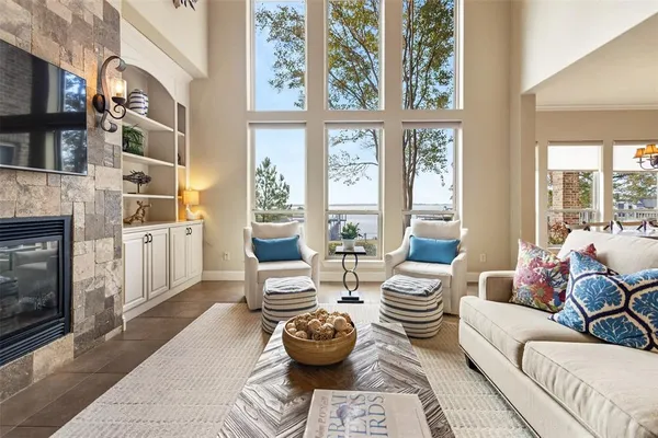 a living room with fireplace furniture and a floor to ceiling window