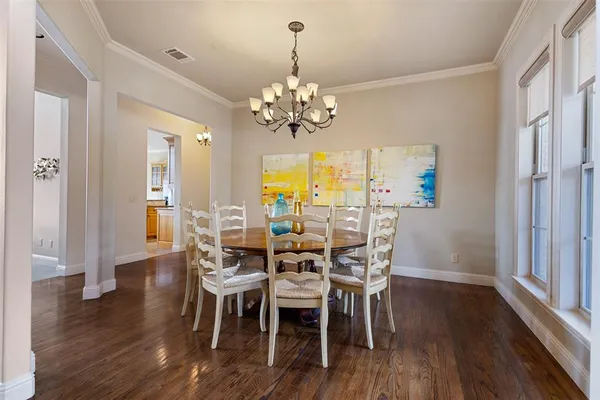 a view of a dining room with furniture a chandelier and wooden floor