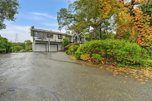 a view of an empty room with wooden floor and a kitchen