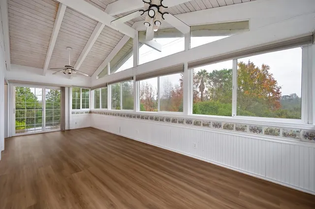 an empty room with fan and windows