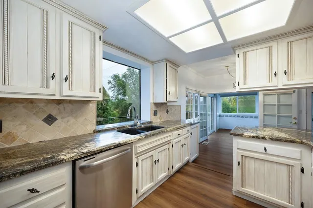 a bathroom with a granite countertop sink a toilet and shower