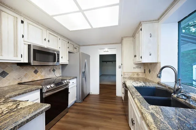 a kitchen with stainless steel appliances white cabinets and a refrigerator