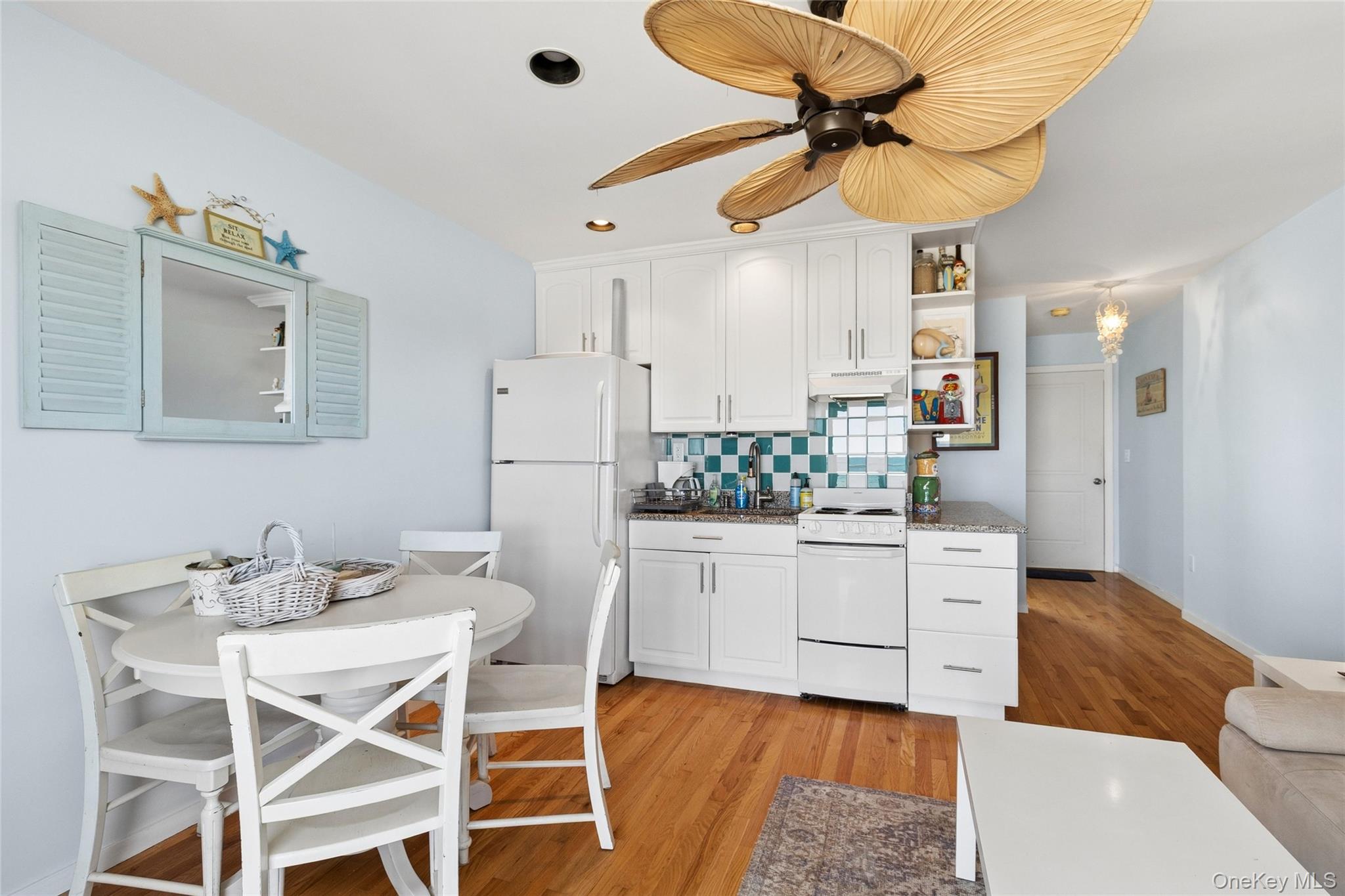 16 Navy Road, Unit 206 Montauk, NY 11954 - Photo 7 of 18 a kitchen with stainless steel appliances kitchen island granite countertop a table chairs and white cabinets