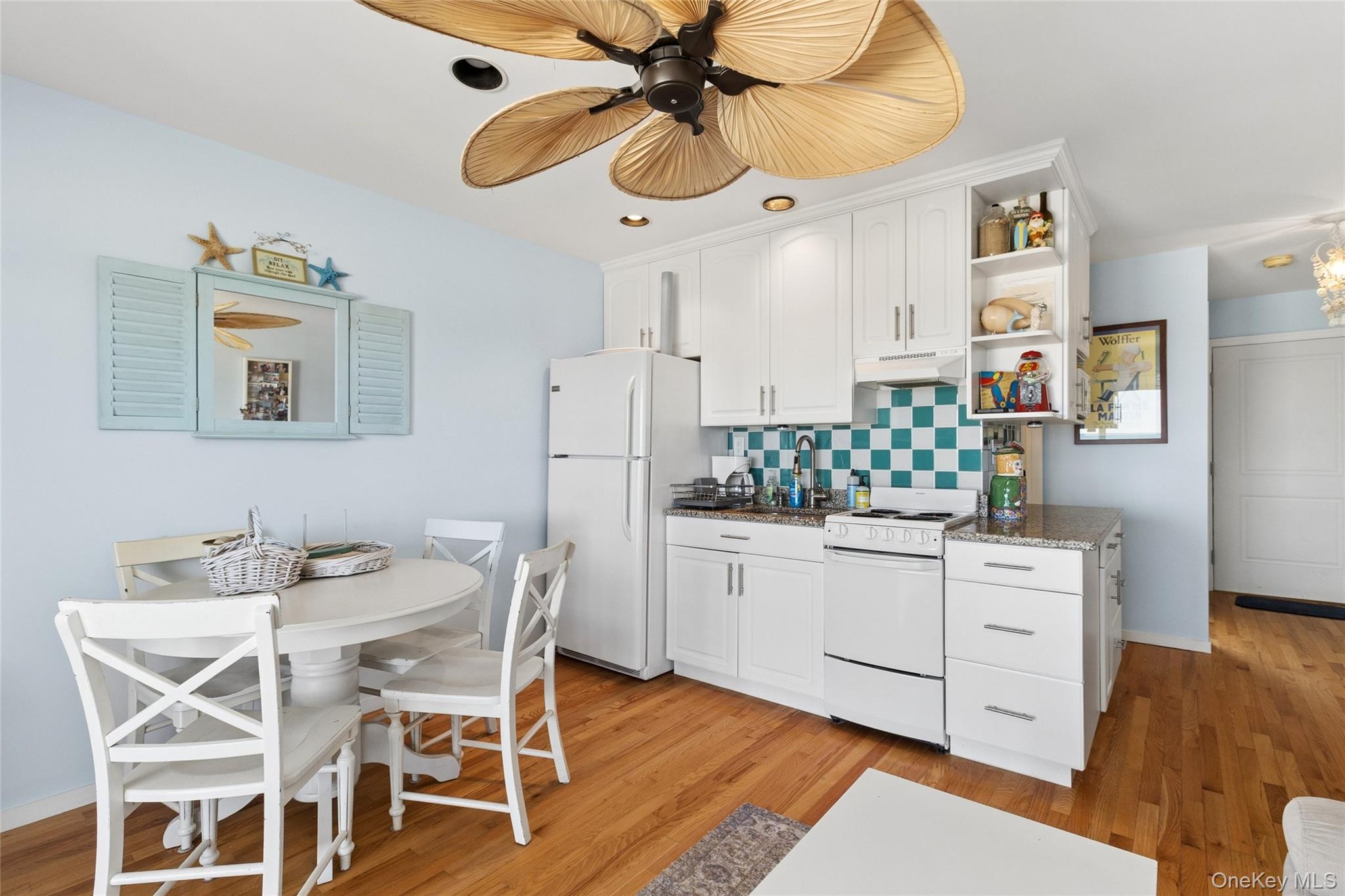 16 Navy Road, Unit 206 Montauk, NY 11954 - Photo 8 of 18 a kitchen with stainless steel appliances kitchen island granite countertop a table and chairs