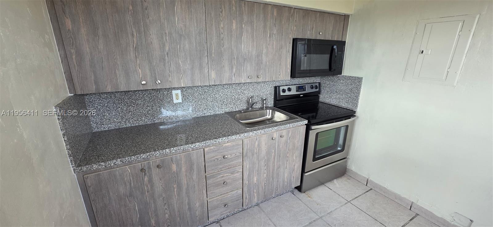 654 West 29th Street, Unit 1 Hialeah, FL 33012 - Photo 8 of 14 a kitchen with stainless steel appliances granite countertop a sink stove and microwave