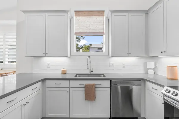 a kitchen with white cabinets and white appliances