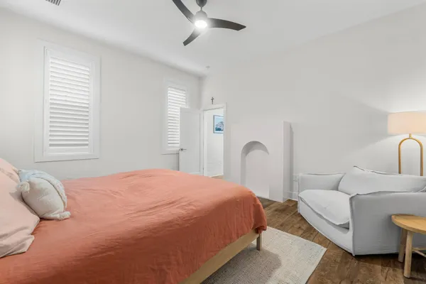 a bedroom with a bed wooden floor and window