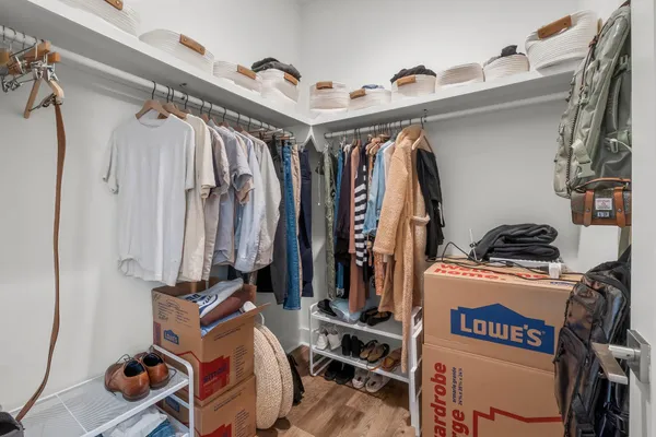 a view of walk in closet with clothes and shoes