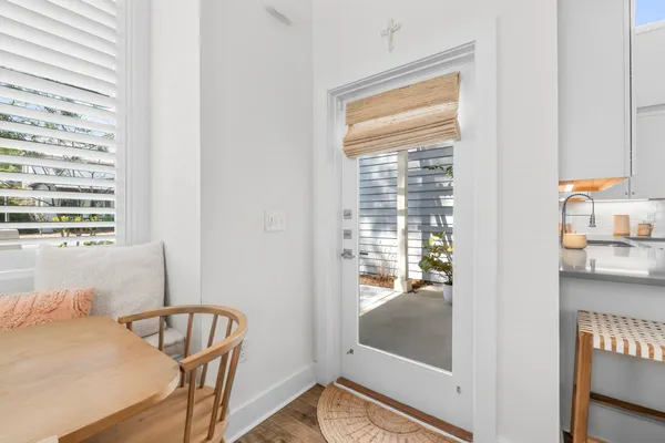 a view of a hallway with a view of kitchen and wooden floor