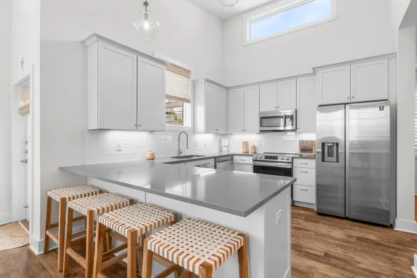 a kitchen with kitchen island a counter top space a sink stainless steel appliances and cabinets