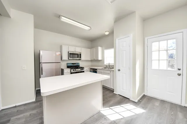 a kitchen with stainless steel appliances a refrigerator and a stove top oven