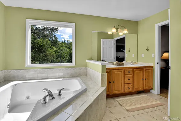 a spacious bathroom with a tub sink and mirror
