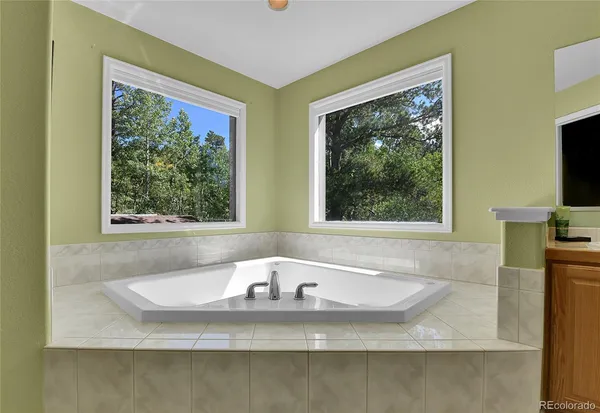 a bathroom with bathtub and window
