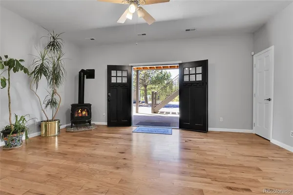a view of an empty room with a window and wooden floor