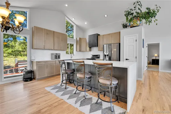 a kitchen with stainless steel appliances a dining table chairs and a refrigerator
