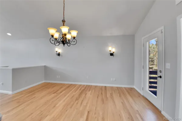 a view of a room with wooden floor and chandelier