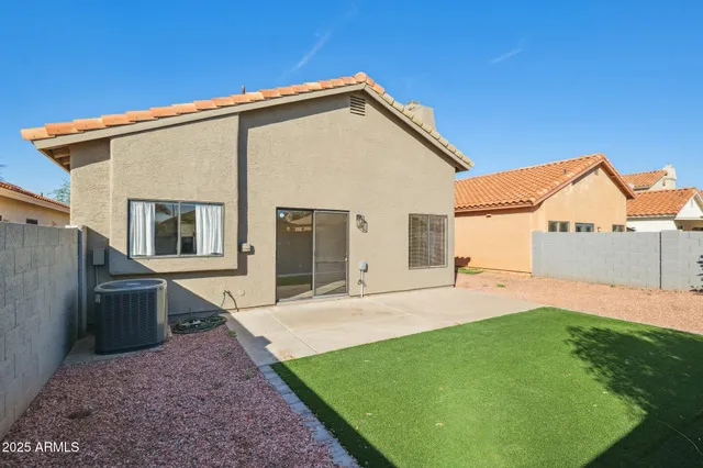 an empty room with chandelier fan and windows