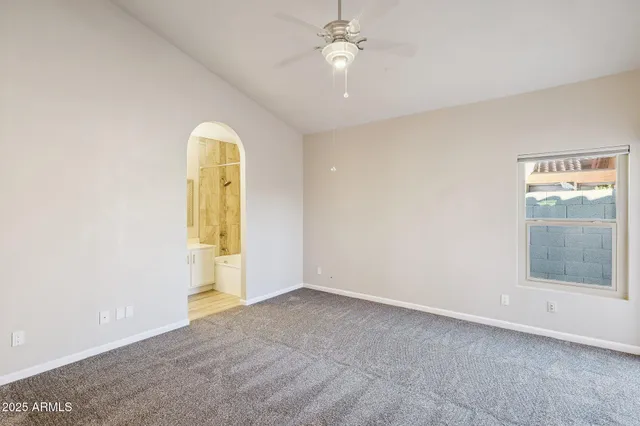 a large white kitchen with kitchen island a large window a sink and stainless steel appliances