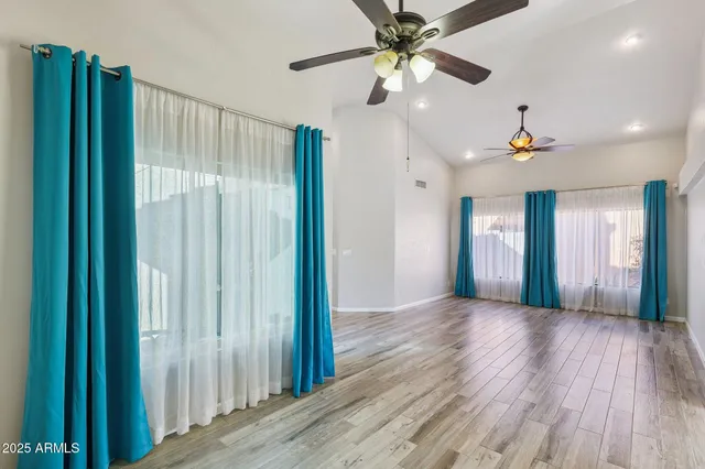 an empty room with closet and windows