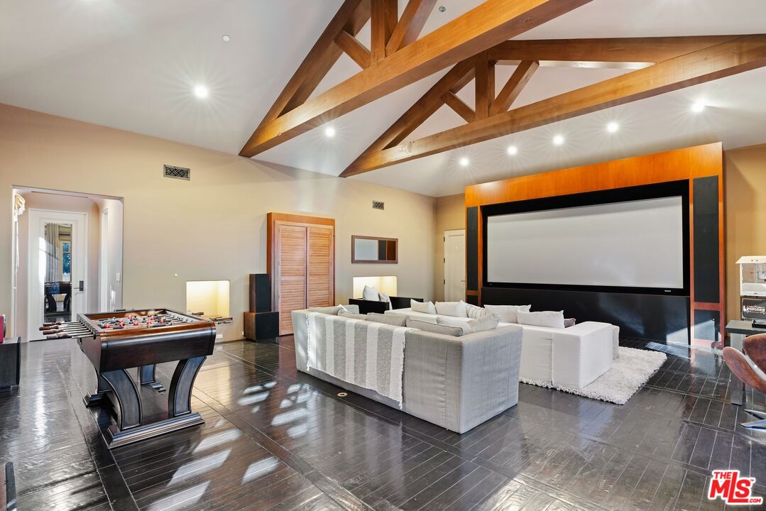 8 Beverly Ridge Terrace Beverly Hills, CA 90210 - Photo 44 of 74 a living room with furniture a projector and a flat screen tv