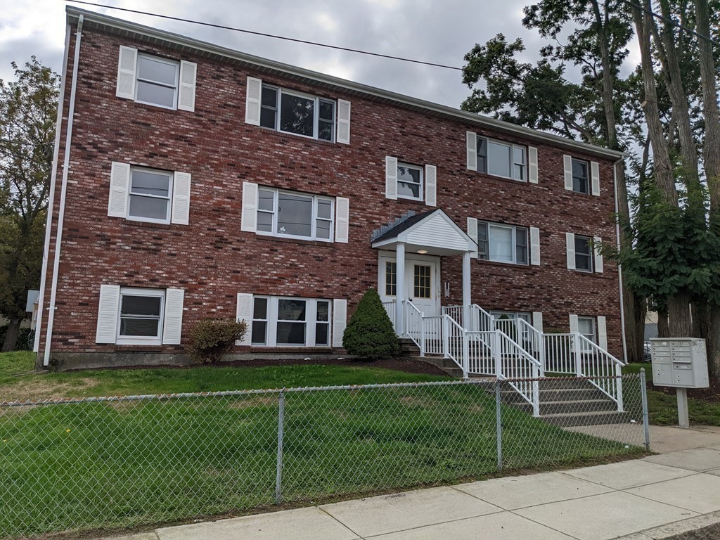 511 Buffinton Street, Unit A Fall River, MA 02721 - Photo 1 of 15 a view of a brick building next to a yard