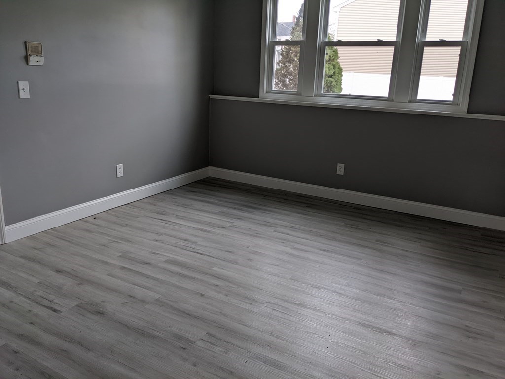 511 Buffinton Street, Unit A Fall River, MA 02721 - Photo 11 of 15 a view of an empty room with wooden floor and a window
