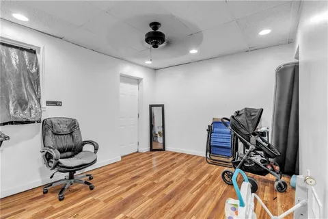 a room with gym equipment and wooden floor