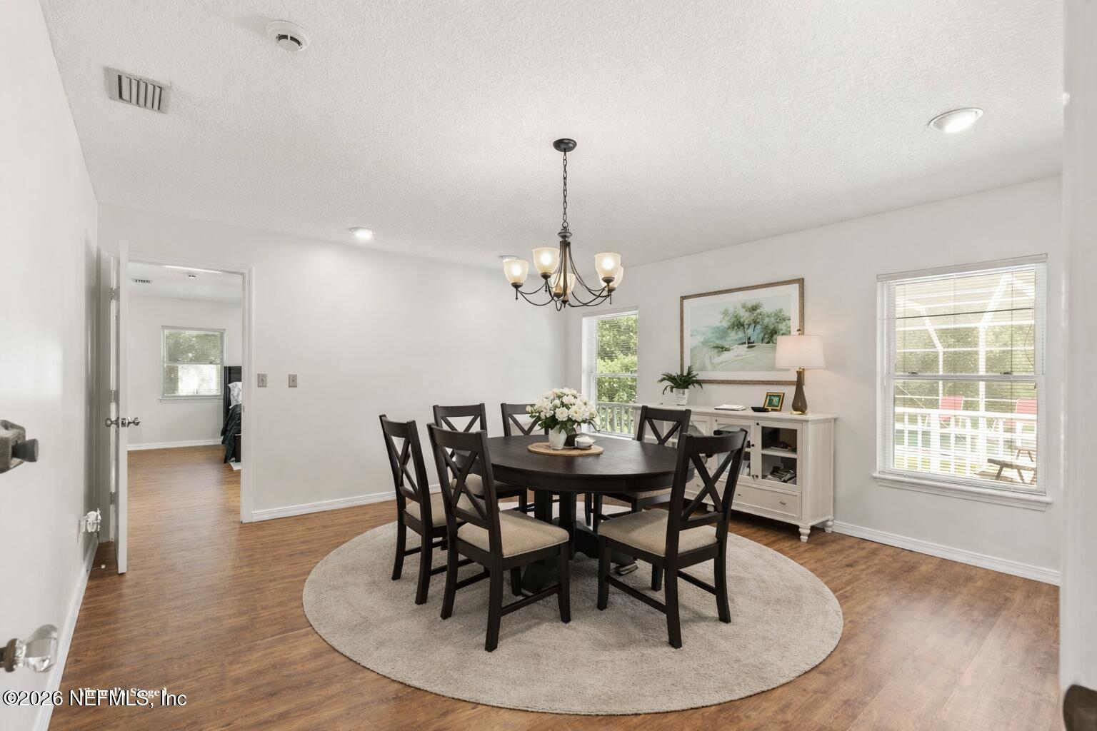 120 Stokes Landing Road St. Augustine, FL 32095 - Photo 12 of 78 a dining room with furniture a chandelier and wooden floor