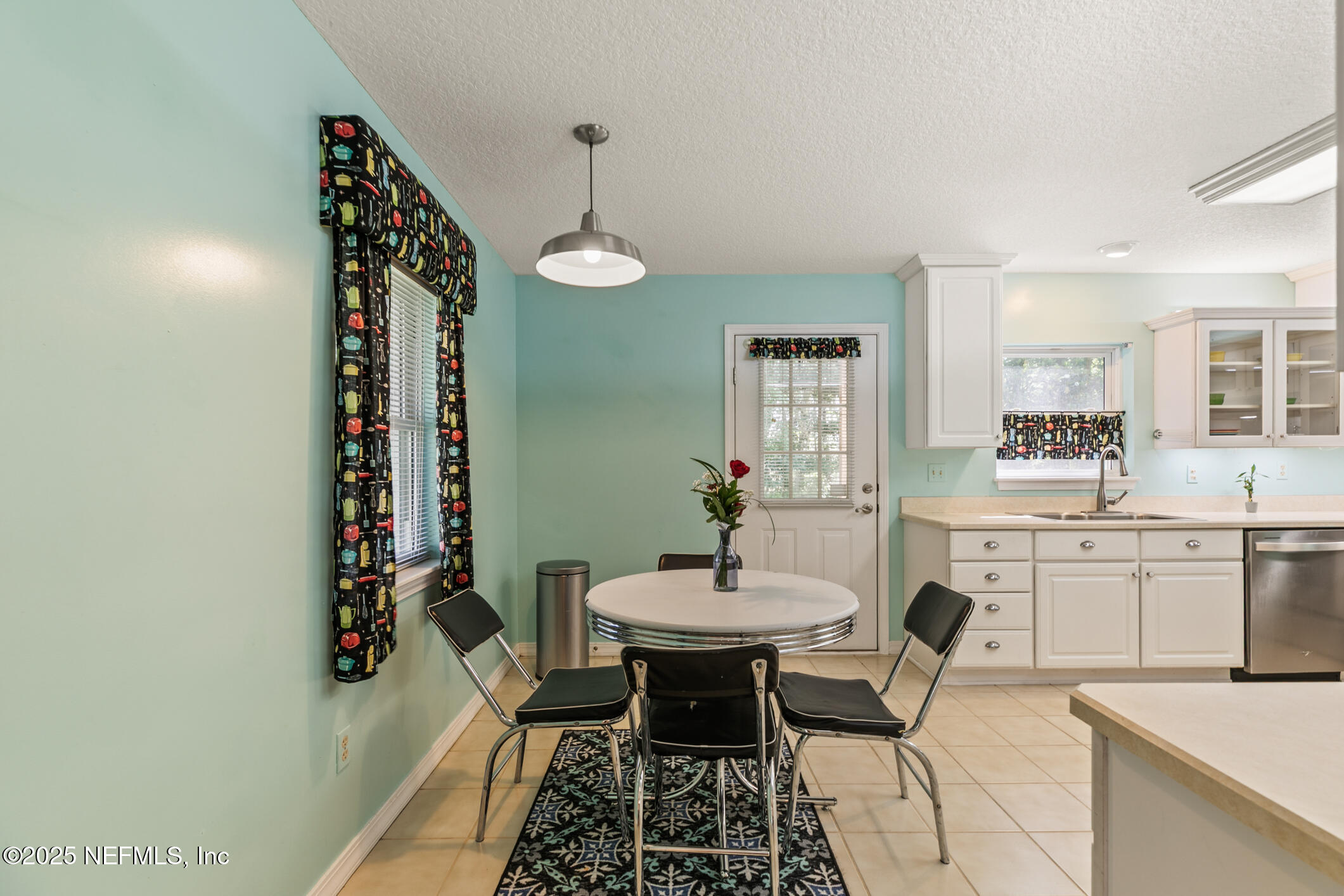 120 Stokes Landing Road St. Augustine, FL 32095 - Photo 23 of 78 a kitchen with a dining table chairs and white cabinets