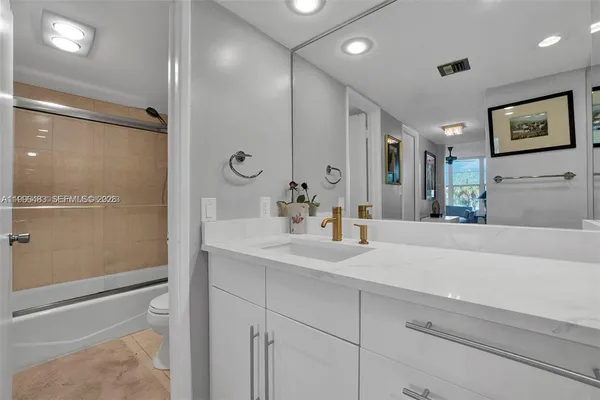 a bathroom with a sink a large mirror and shower