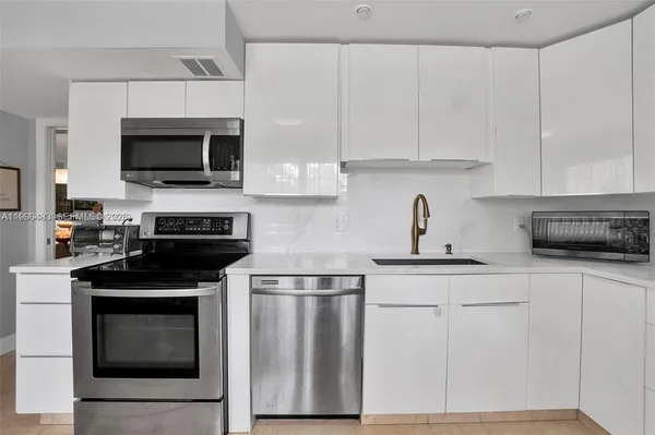 a kitchen with white cabinets and stainless steel appliances