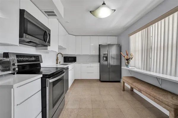 a kitchen with stainless steel appliances granite countertop a refrigerator a stove a sink and dishwasher