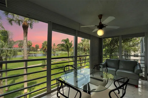 a view of a chairs and table in patio next to a yard