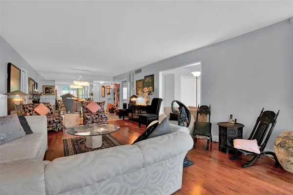a living room with lots of furniture hard wood floor and a window