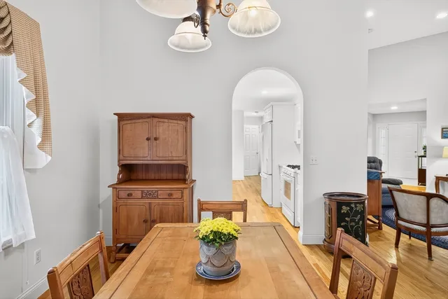a living room with kitchen island furniture a chandelier and a view of kitchen