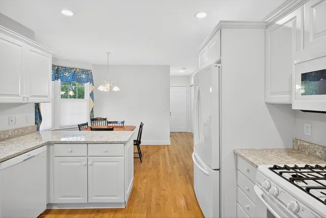 a kitchen with white cabinets and appliances