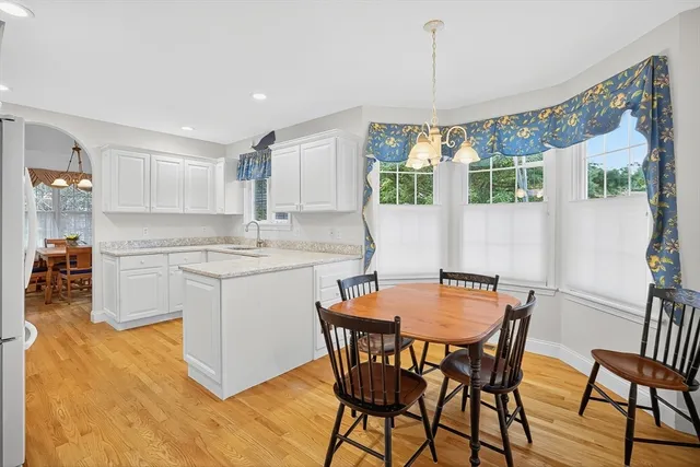 a kitchen with a table chairs a sink dishwasher window and cabinets
