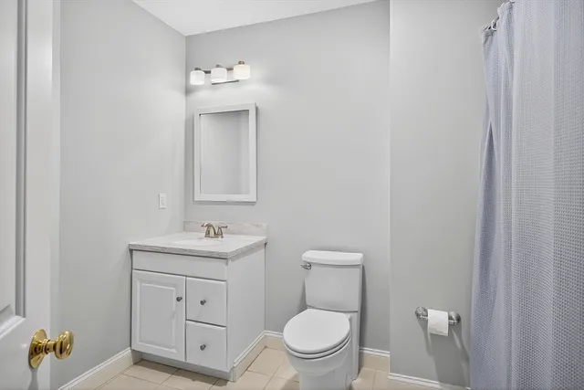 a bathroom with a toilet sink vanity and mirror
