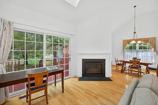 a living room with furniture a fireplace and a floor to ceiling window