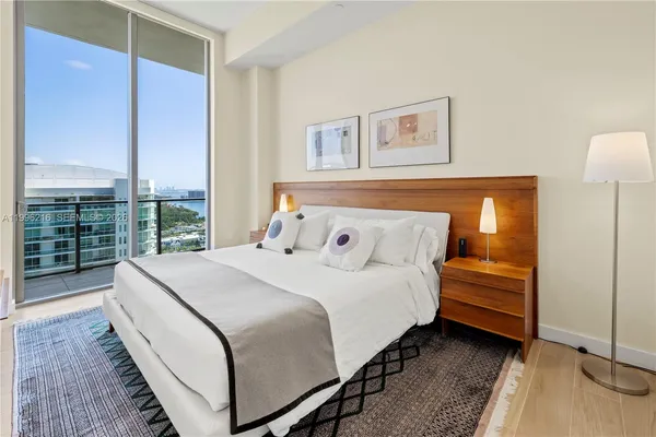 a bedroom with a bed and a large window