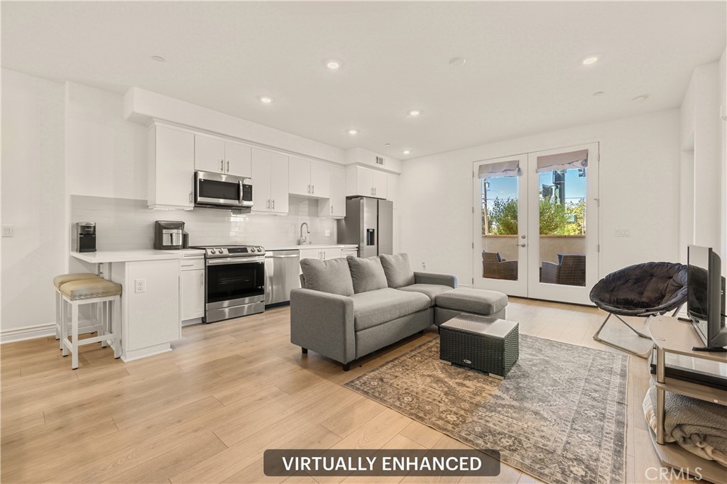 a living room with furniture a flat screen tv and kitchen view