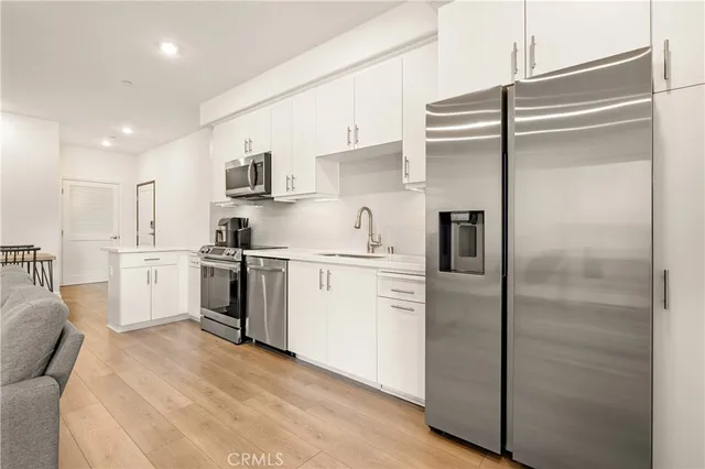 a kitchen with a refrigerator and white cabinets