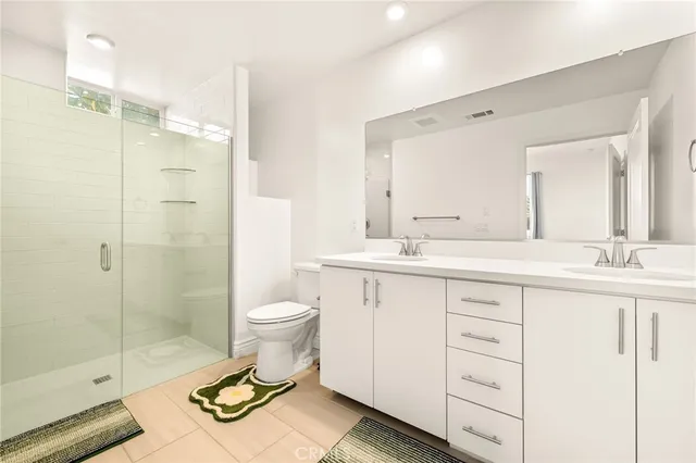 a bathroom with a double vanity sink toilet and shower